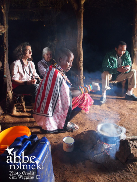people in a hut around a cooking fire